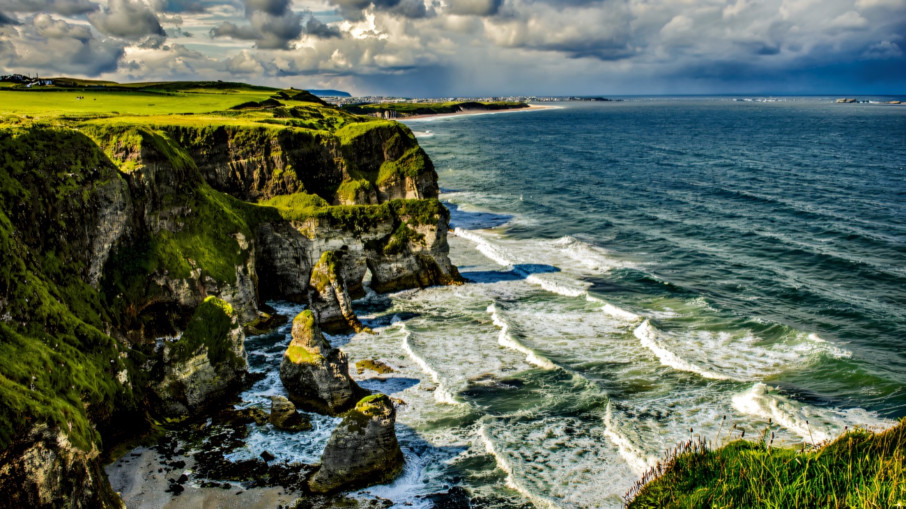 Waves breaking against the cliffs under stormy skies