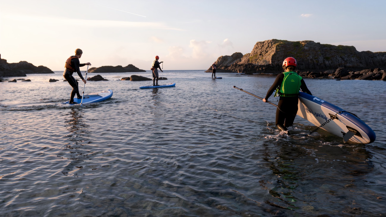 A paddleboard group exploring the rocky Antrim shoreline