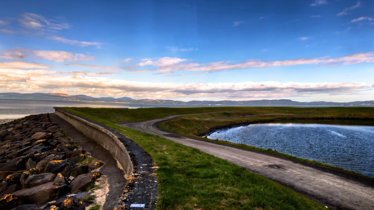 The embankment path curves between the sea wall and a quiet lagoon on Lough Foyle.