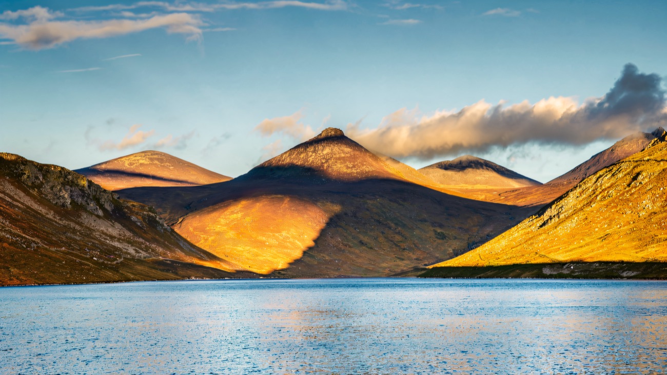 Slieve Binnian mirrored in the still blue water of the valley