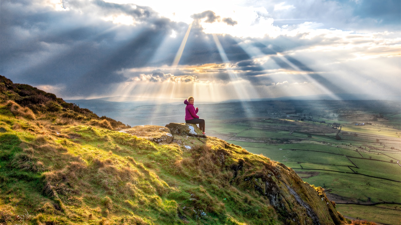 Sunrays break over the Antrim plain from a rest on the summit rocks