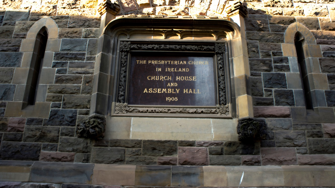 A carved datestone reading Church House and Assembly Hall 1905 set into the stone wall