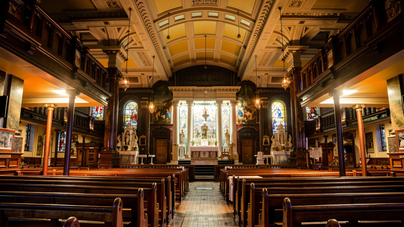 The richly decorated interior, marble columns and stained glass leading the eye to the high altar.