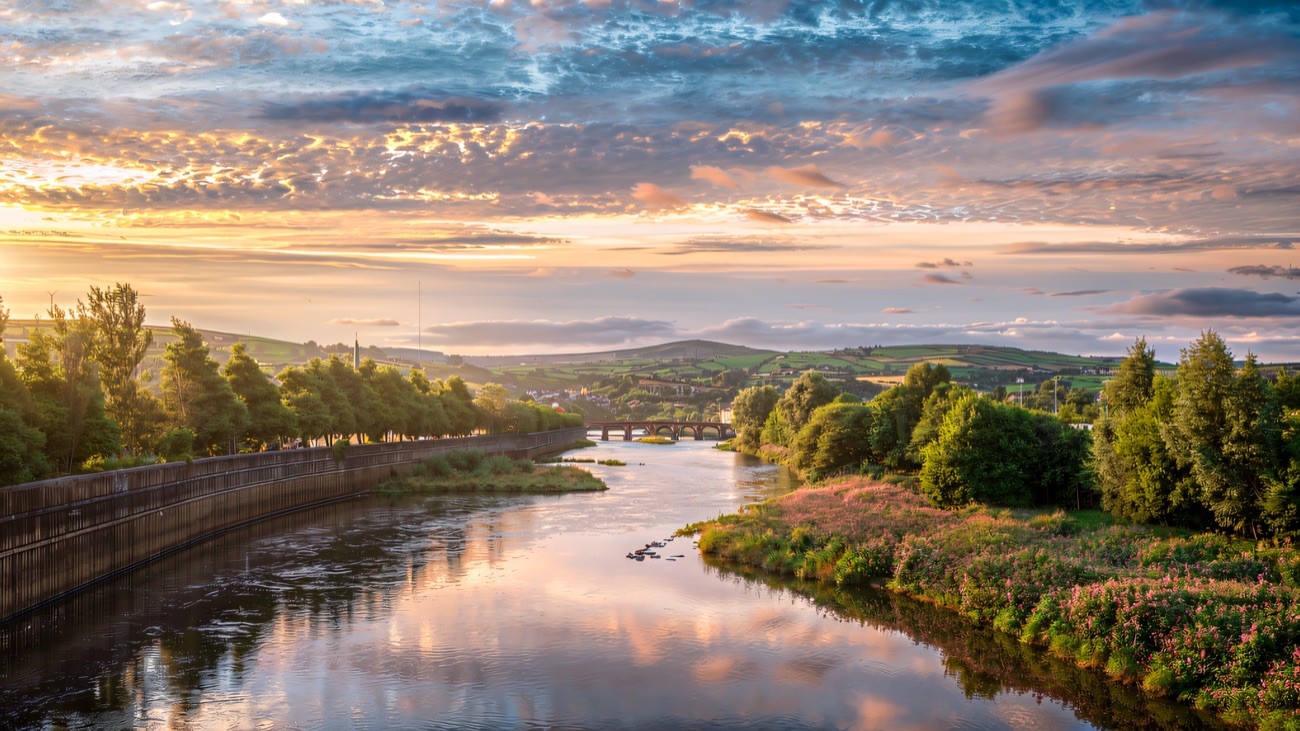 Soft dawn light over the river and its wooded banks