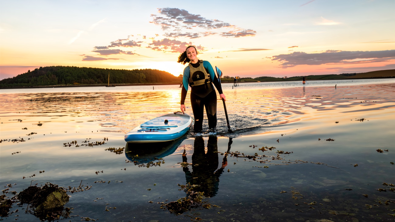 Stepping ashore at dusk after a paddle on the mirror-flat lough