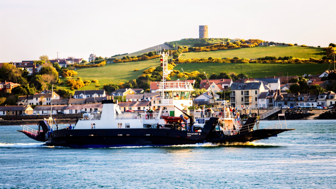 The Portaferry ferry crossing the narrows, the old windmill tower on the gorse-yellow hill behind.