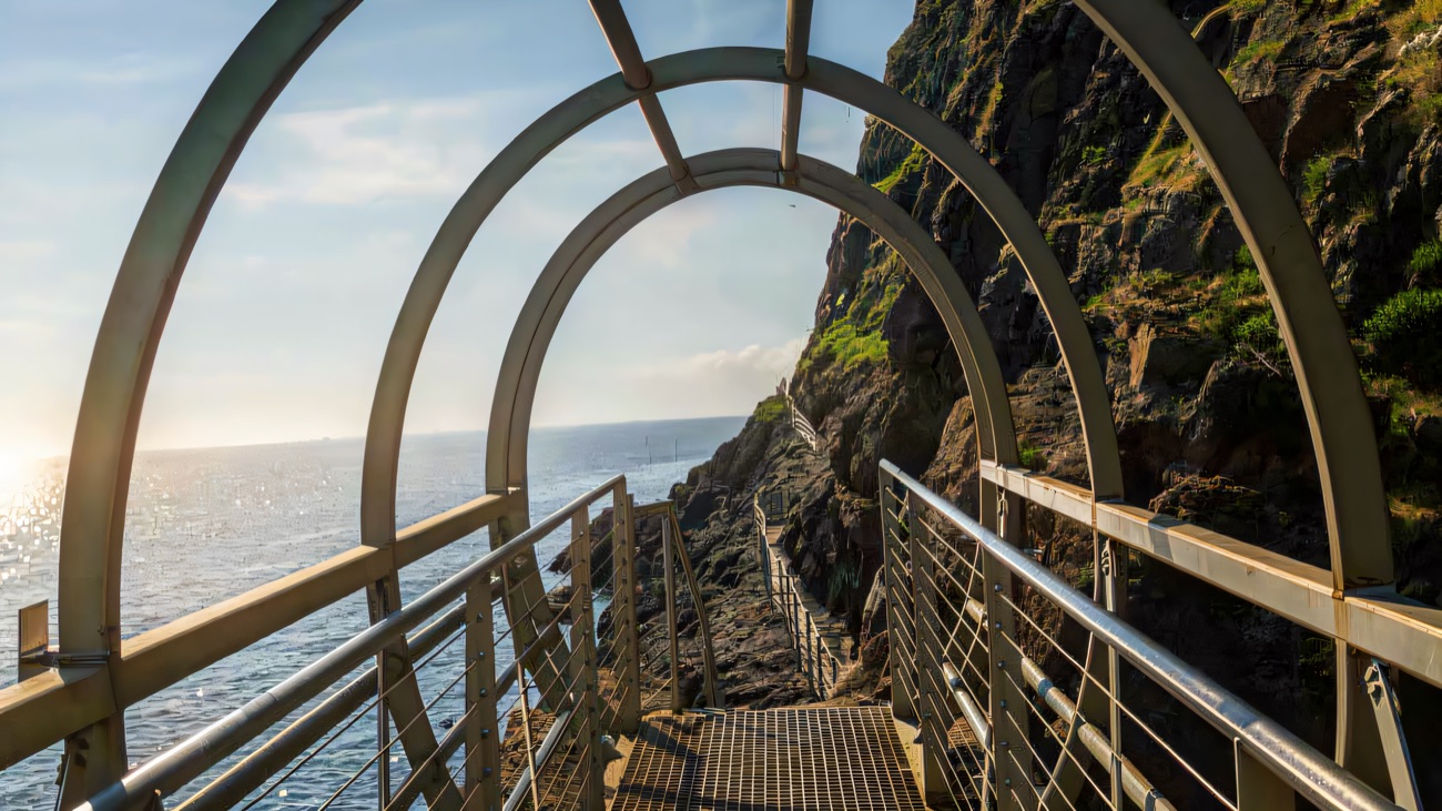 Looking through the arched tubular cage walkway out to the open sea