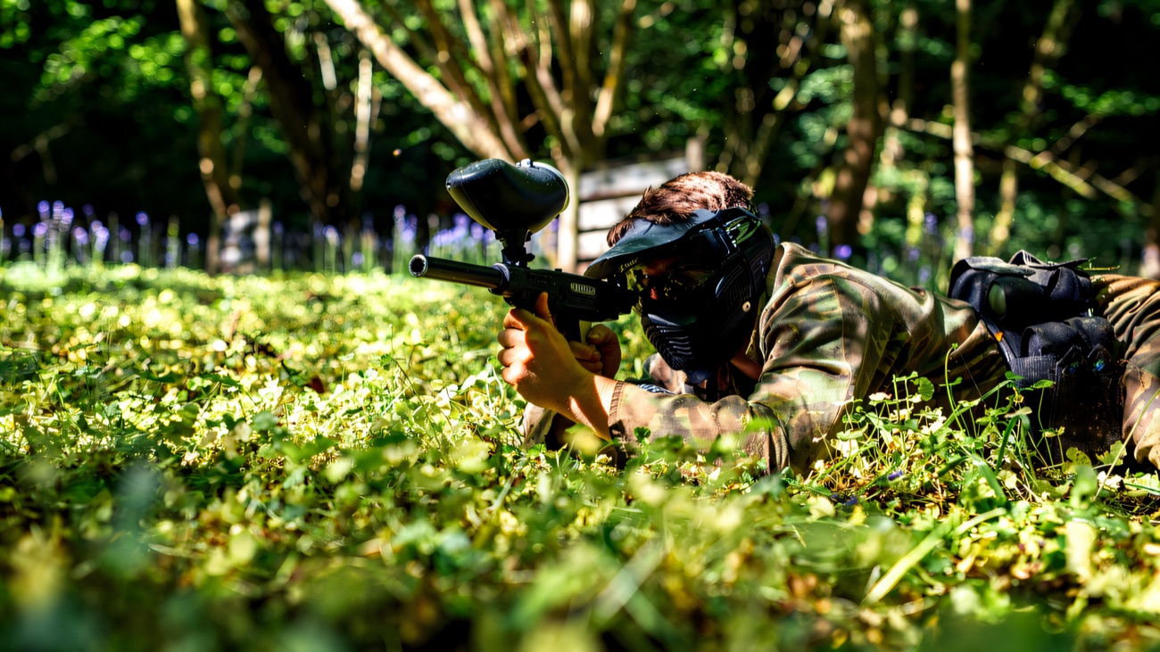 A masked player lying low in the bluebell woods, marker at the ready