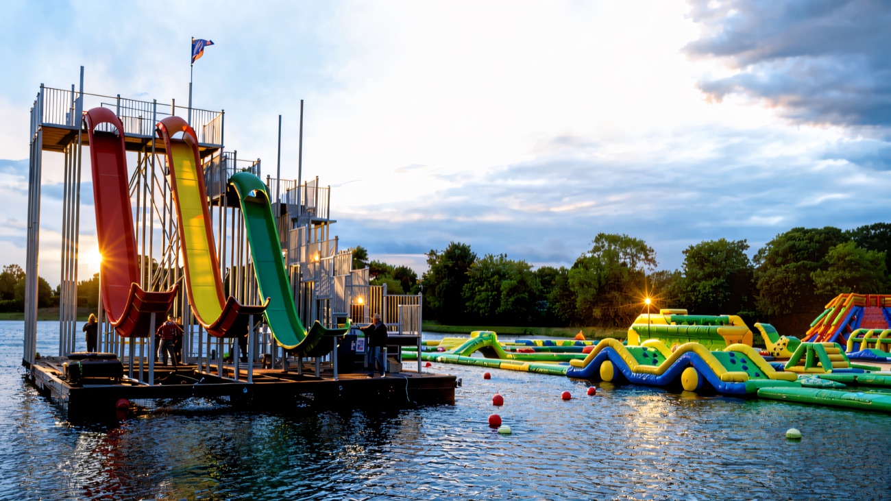 The tall floating slide tower beside the obstacle course