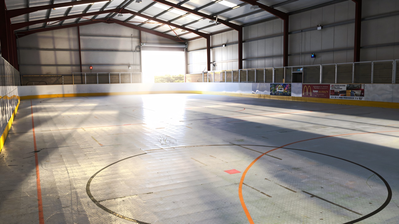 The empty rink in daylight, showing the barriers and marked-out floor