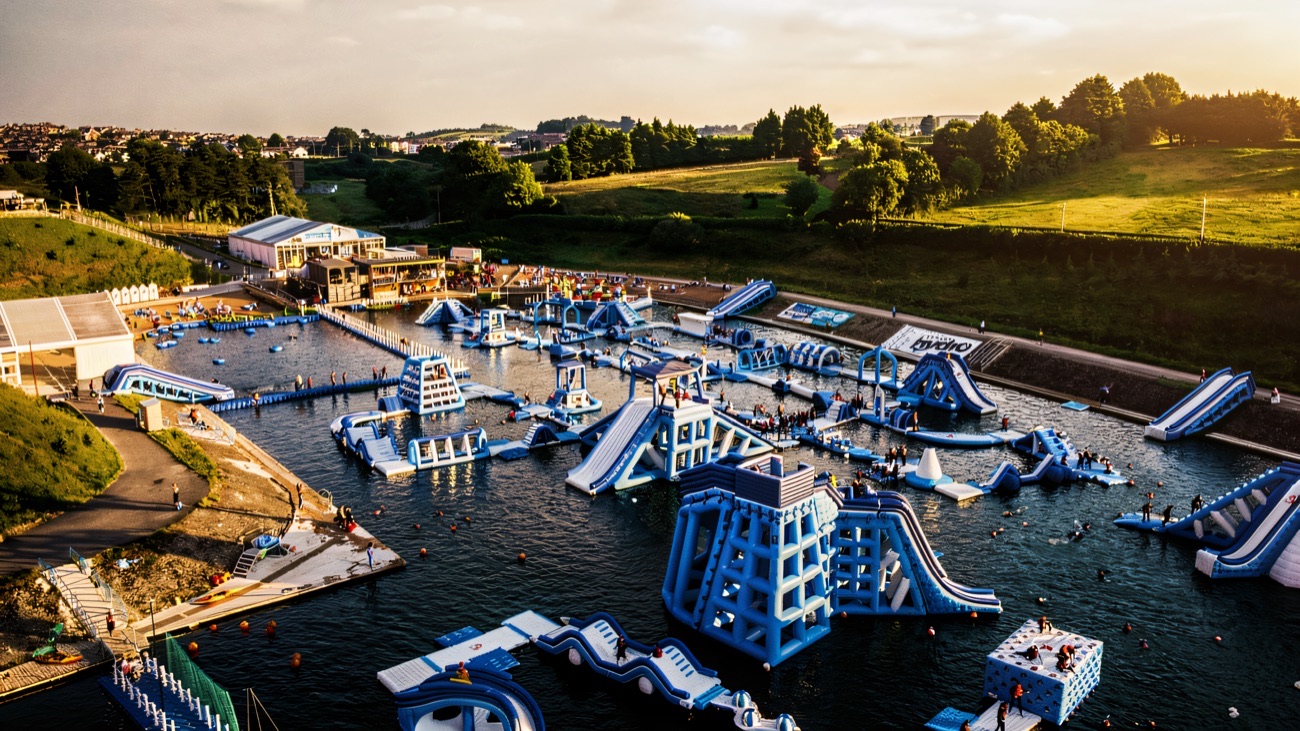 Aerial view of the huge inflatable aqua park floating on the lake at Let's Go Hydro at sunset