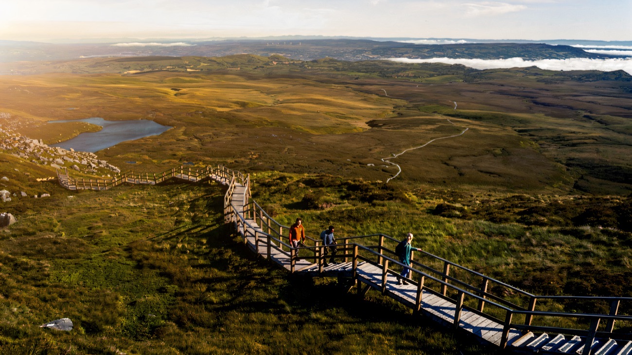 Walkers on the timber summit steps of Cuilcagh with the vast Fermanagh lakelands spread out below