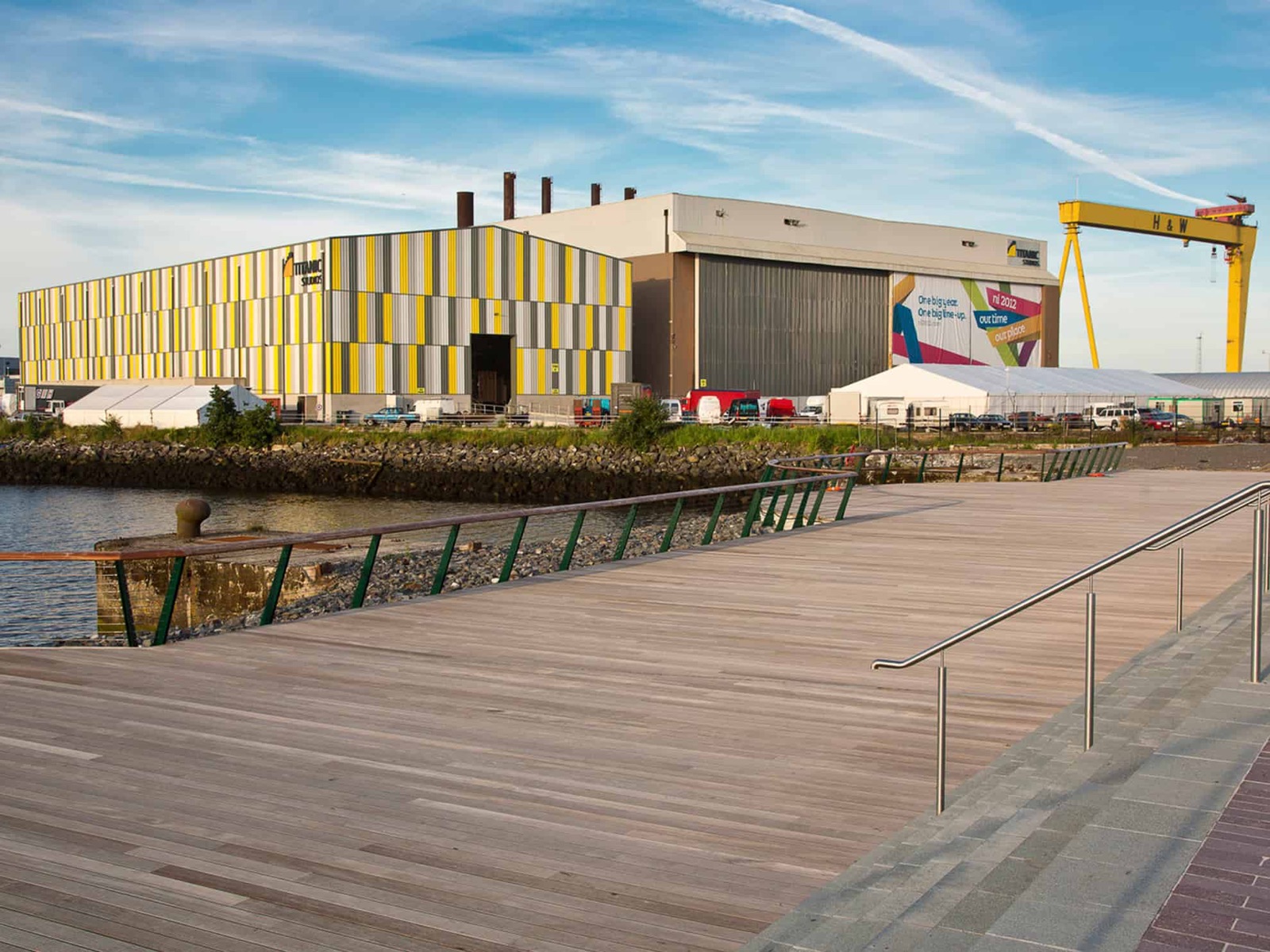 Titanic Studios, the striped yellow and silver Paint Hall, with the Harland & Wolff crane behind, seen from the Titanic Quarter boardwalk