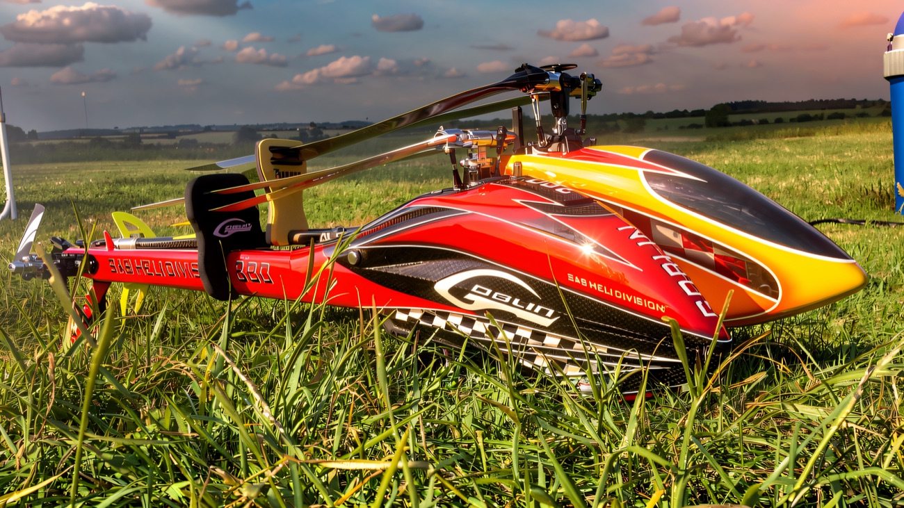 A red and yellow model helicopter resting in the grass on a bright flying day