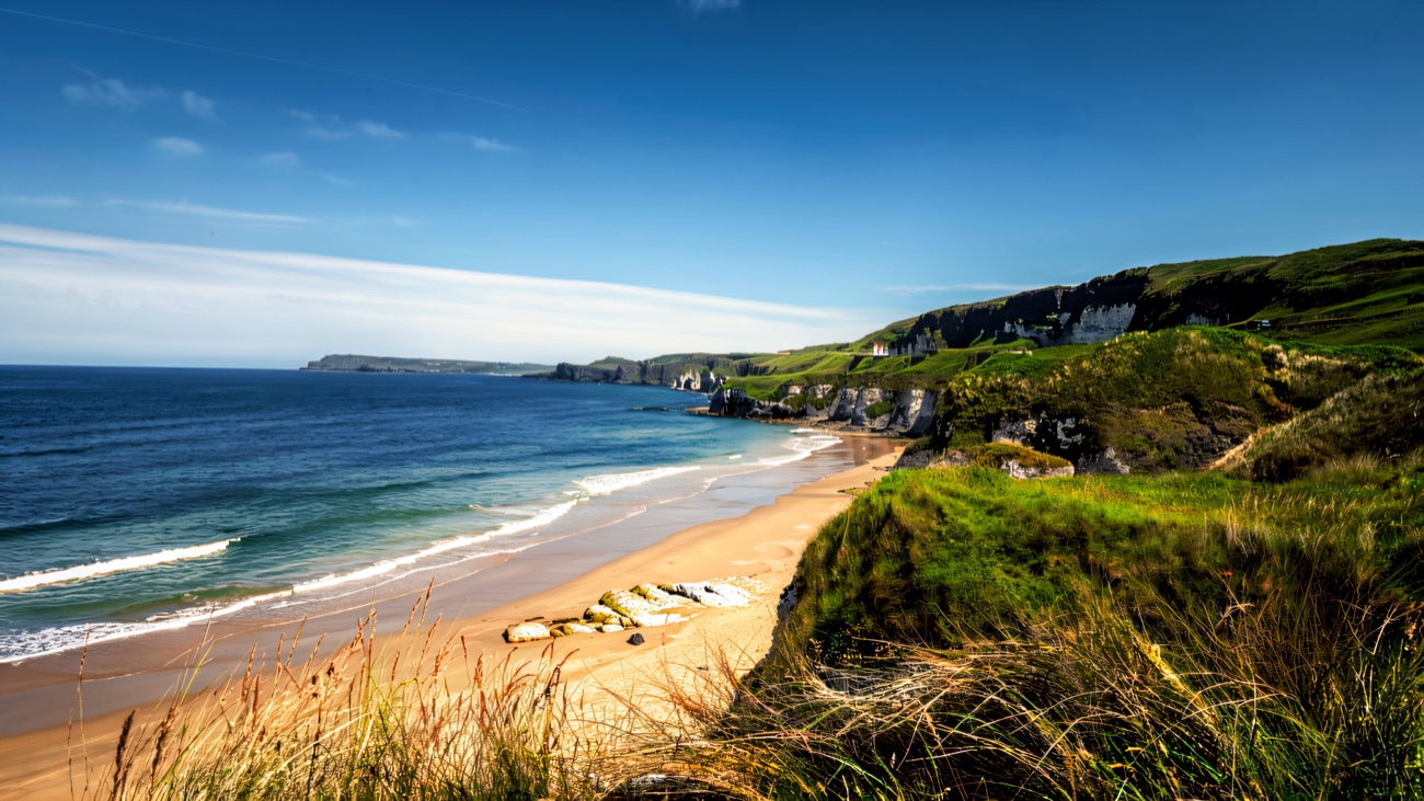 Whiterocks beach curving away below the marram grass, with the white chalk cliffs and sea stacks beyond
