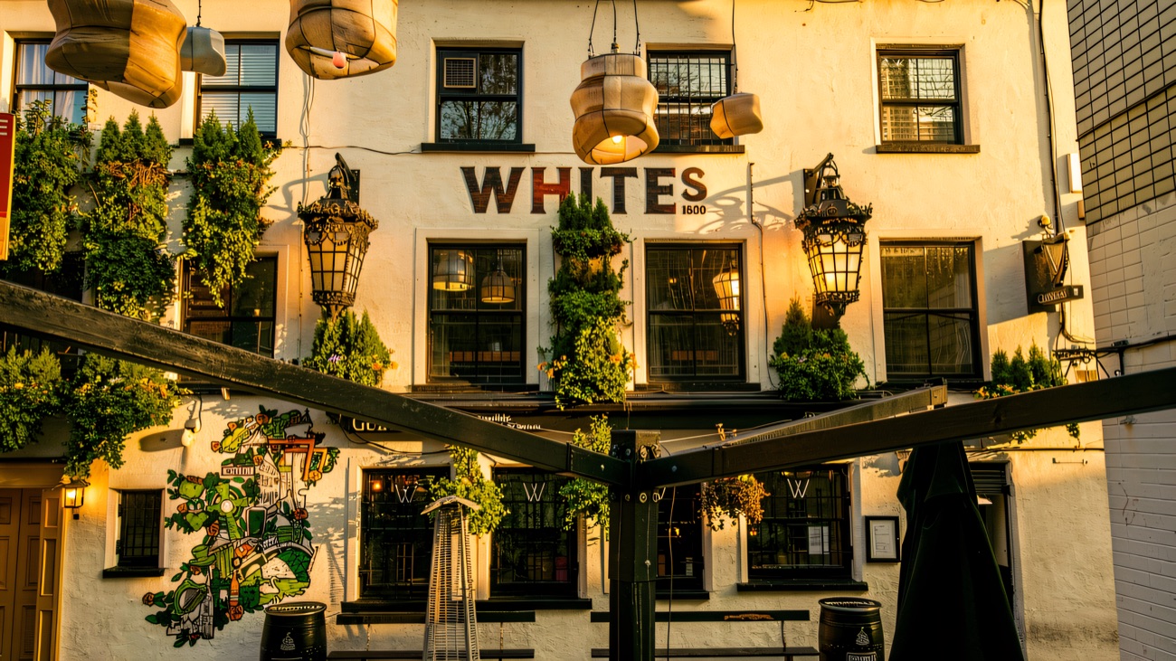 The courtyard with benches and hanging lanterns below the Whites 1630 sign